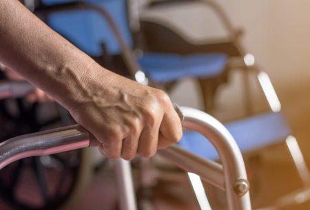asian-old-woman-standing-with-her-hands-walker-stand